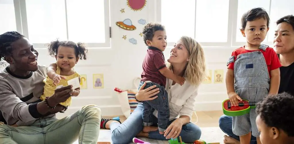 Children playing with toys alongside their parents