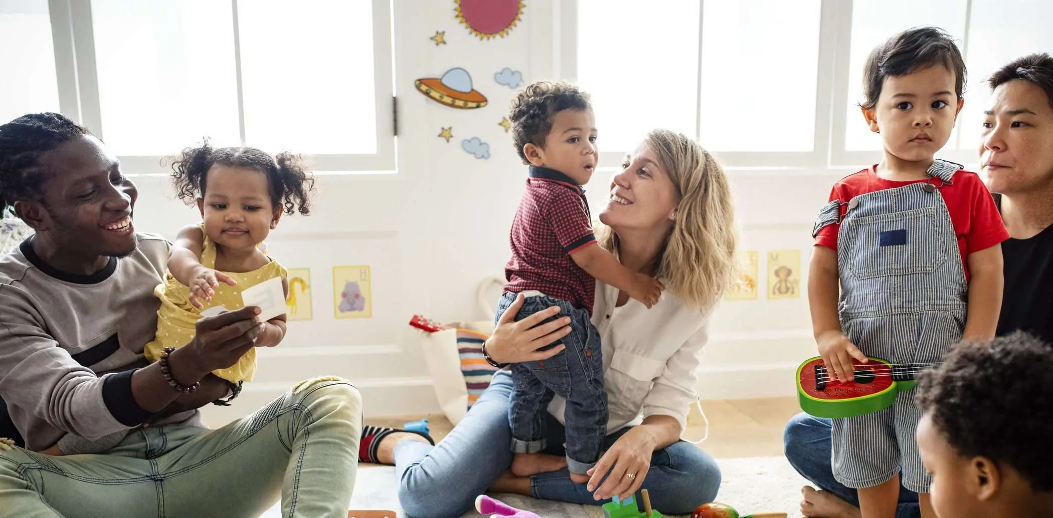 Children playing with toys alongside their parents